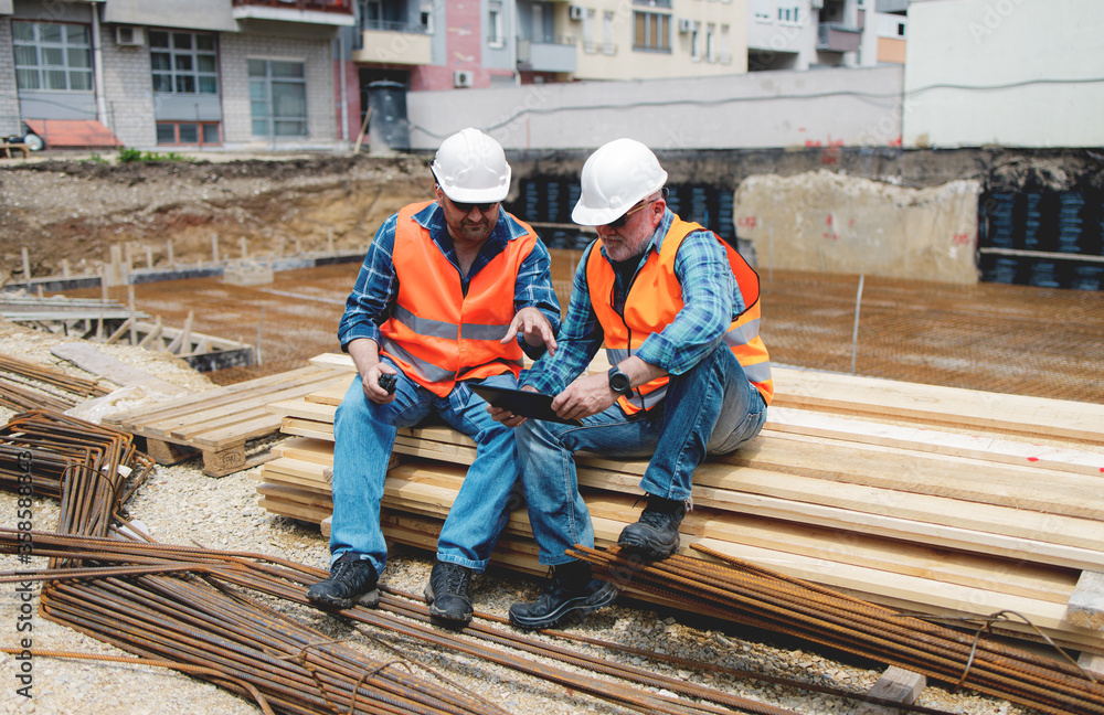 Managers, engineers discuss the further process of work on the construction site Managers, engineers discuss the further process of work on the construction site