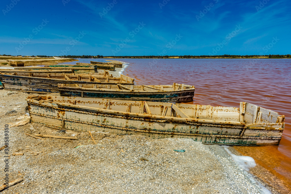 Φωτογραφία It's Wooden boat on the coast of the pink lake in Senegal called Lake Retba or L