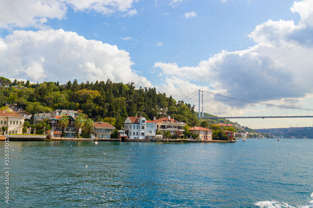 Sunny landscape with bright houses over the water edge of the Bosphorus Strait in Istanbul, Turkey