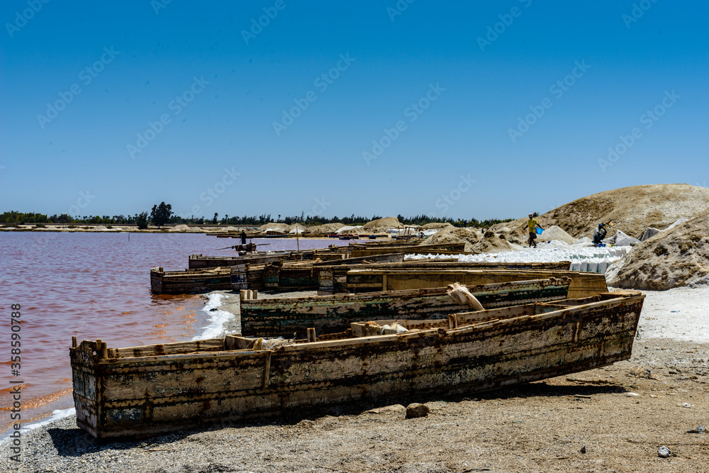 It's African boats on the coast of the pink water lake in Senegal, Africa It's African boats on the coast of the pink water lake in Senegal, Africa