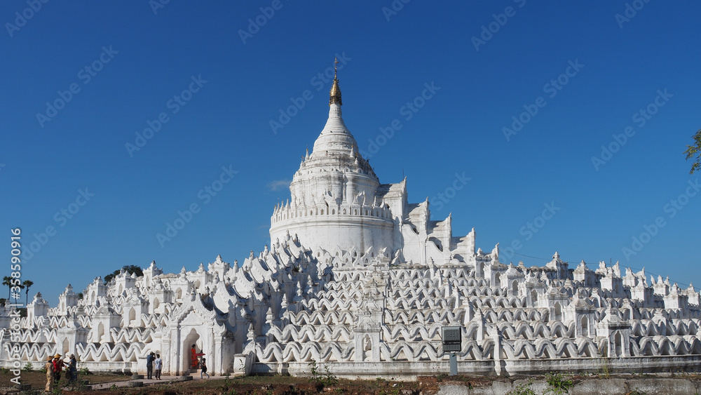 Hsinbyume pagoda, stunning white pagoda built in 1816 by Prince Bagydaw, as a memorial of his wife. The unique architecture followed Buddhist cosmology, Mount Meru as center and seven mounts around.