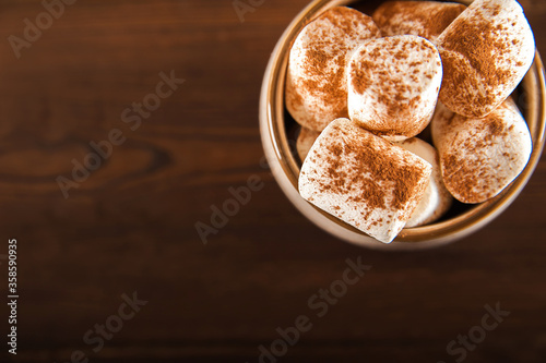 Concept with marshmallows in a circle on a dark background. Autumn, coffee, tea, mug, marshmallows, cozy. Fall concept closeup and copy space on dark background.