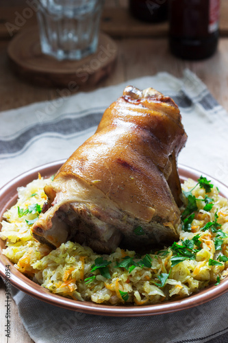 Baked pork knuckle served with stewed cabbage and beer. Rustic style.