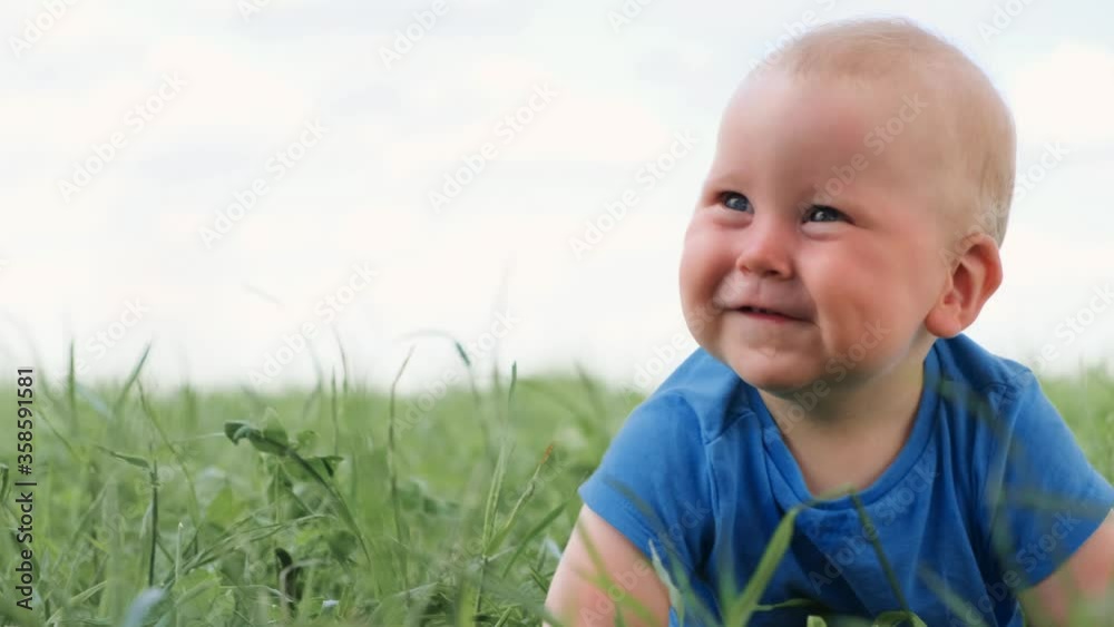 4k. baby sitting crawling on green grass and smiling broadly. Excited cute little caucasian child. Happy childhood and baby healthcare 4k. baby sitting crawling on green grass and smiling broadly. Excited cute little caucasian child. Happy childhood and baby healthcare