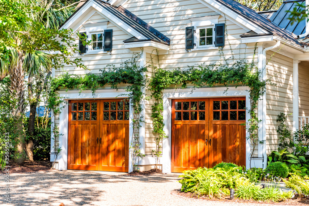 Naklejka premium American residential house building in Charleston, South Carolina with two garage doors exterior with wooden architecture and ivy climbing plant
