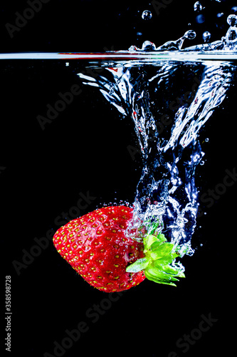 A strawberry splashing into water.