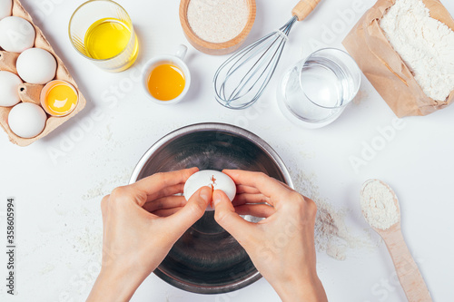 Cooking dough, female's hands cracking egg