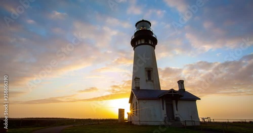 Lockdown time lapse shot of Yaquina Head Lighthouse against orange sky during sunset - Newport, Oregon photo