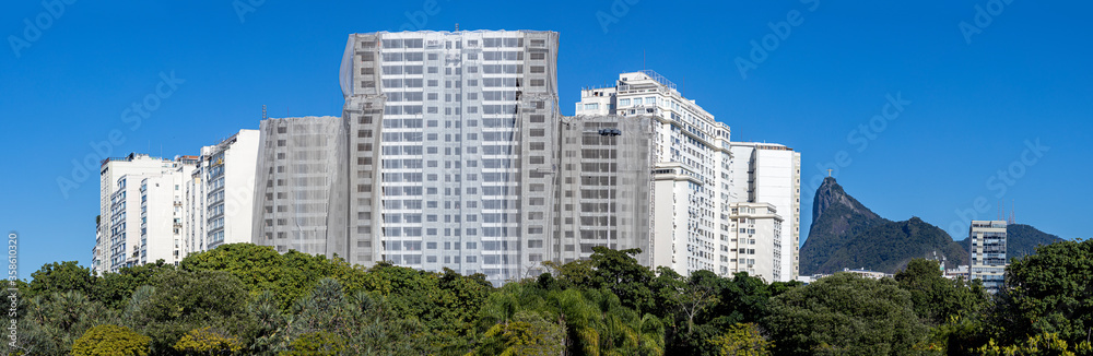 Panorama of Flamengo neighbourhood with real estate under construction luxury apartments rising above vegetation of a city park in Rio de Janeiro with the Corcovado mountain against a clear blue sky