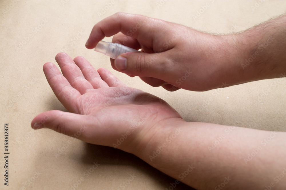 A man applying antibacterial gel on his left hand. A man applying antibacterial gel on his left hand.