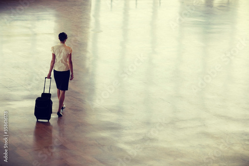 Businesswoman Walking With Wheeled Suitcase