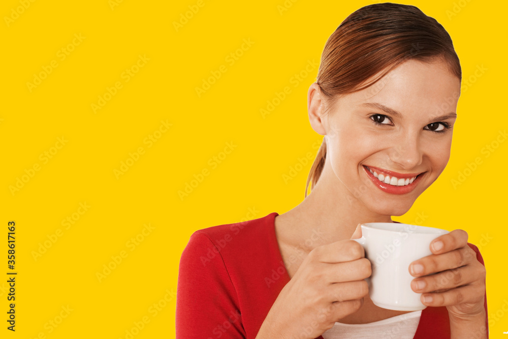 Beautiful woman drinking coffee against yellow background Beautiful woman drinking coffee against yellow background