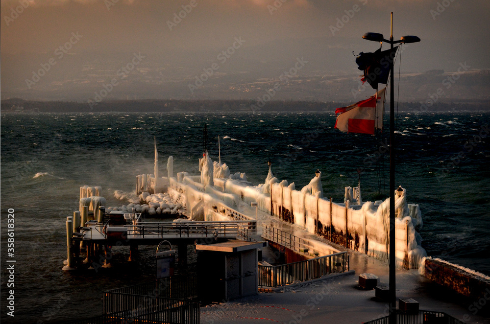 Ponton gelé au bord du lac leman à Ivoire avec drapeau savoyard Stock ...