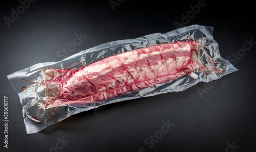 Obraz na plátně Raw veal spare loin ribs St Louis cut offered as closeup vacuum packed in plasti