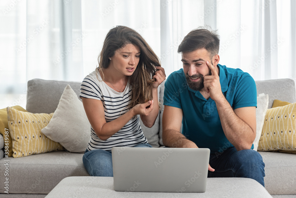 Young guy gets bored while his girlfriend shows her friend online over the laptop how her hairdresser ruined her hair Young guy gets bored while his girlfriend shows her friend online over the laptop how her hairdresser ruined her hair