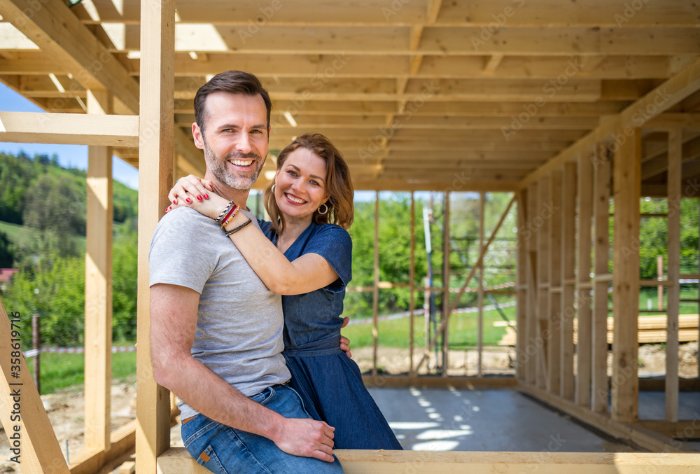 Couple standing on future window in construction site of their new ...