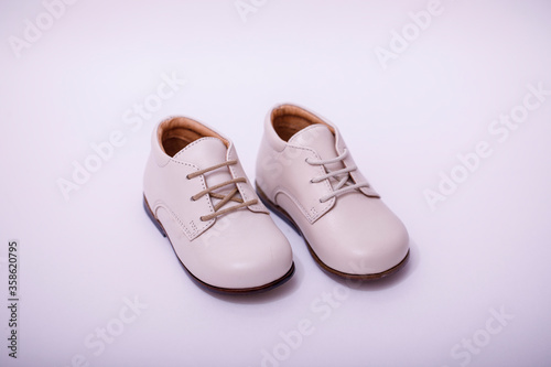 Small child white leather shoes isolated on white background.
