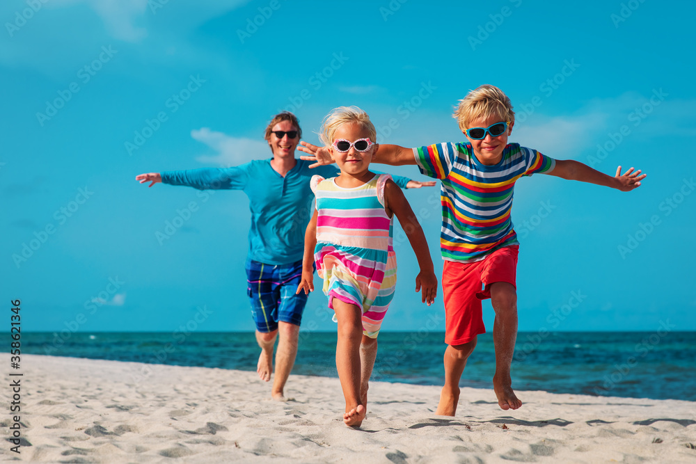 happy family -father with son and daughter run play at beach happy family -father with son and daughter run play at beach