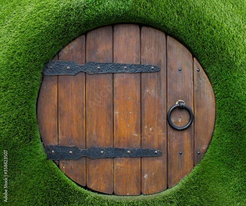 An unusual round door is like an entrance to a fairy-tale world photo