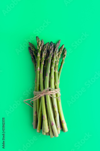 asparagus on a plain green background. view from above. color background. vertical orientation.