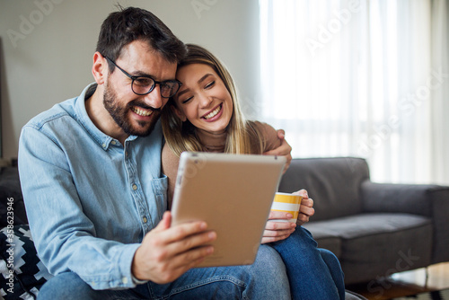 Satisfied couple using tablet at home