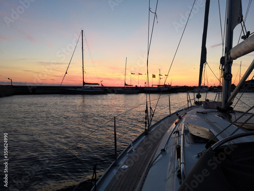 jacht wpływający o zachodzie słońca do portu Grönhögen © Marcin