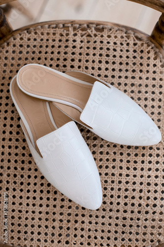 beautiful women's shoes on legs and layouts, leather white mules and loafers, in the interior of a room or office, a girl shoes, blue skirt and white shoes, a noble and elegant style, modern and trend