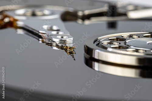 Macro shot of a magnetic needle on a hard disk platter, open HDD disk, perfectly clean surface.