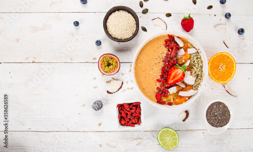 Smoothie bowl with fresh berries, nuts, seeds, fruit and vegetables. Healthy breakfast.