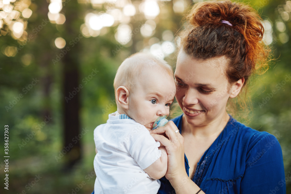 Beautiful blonde mom with he baby in forest,summer time. Beautiful blonde mom with he baby in forest,summer time.