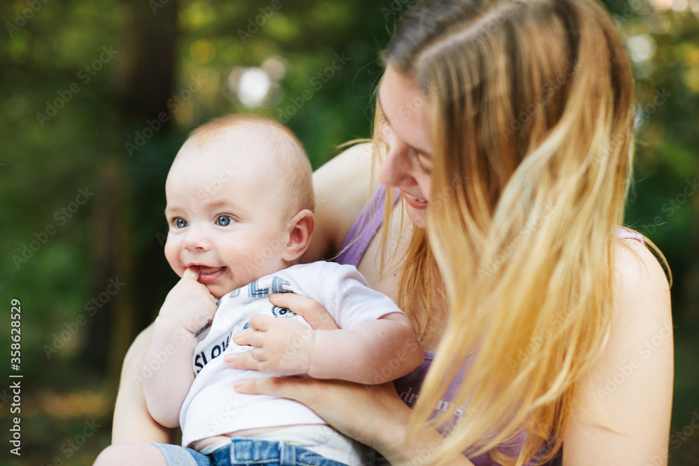 Beautiful blonde mom with he baby in forest,summer time. Beautiful blonde mom with he baby in forest,summer time.