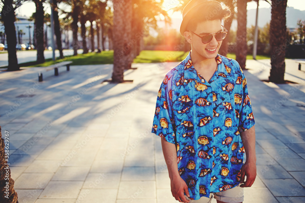 Portrait of a stylishly-dressed young man standing in the street, handsome fashionable male posing outdoors in the city Portrait of a stylishly-dressed young man standing in the street, handsome fashionable male posing outdoors in the city