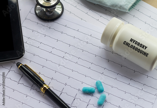 Doctor's desk. Medical elements related to coronavirus. Medication dispenser with the word hydroxychloroquine written on it. photo