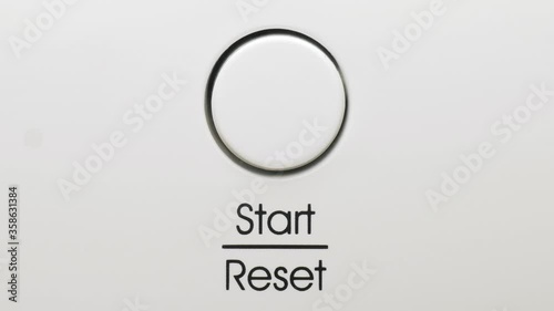 Finger presses start reset button on a dishwasher macro photo