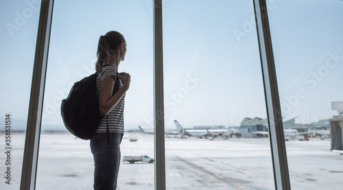 young woman traveler looking through airport window © kieferpix