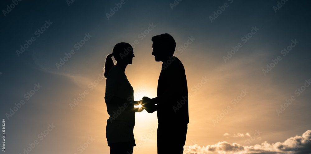Young man and woman holding hands looking into each others eyes. Love and people relationships concept. 