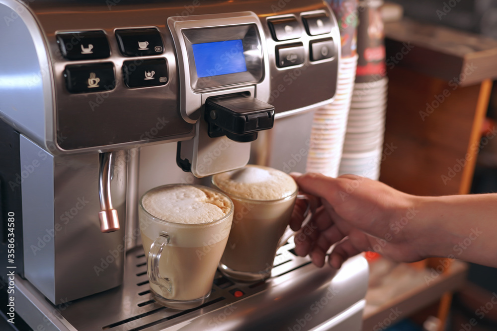 the Barista prepares coffee using a coffee machine