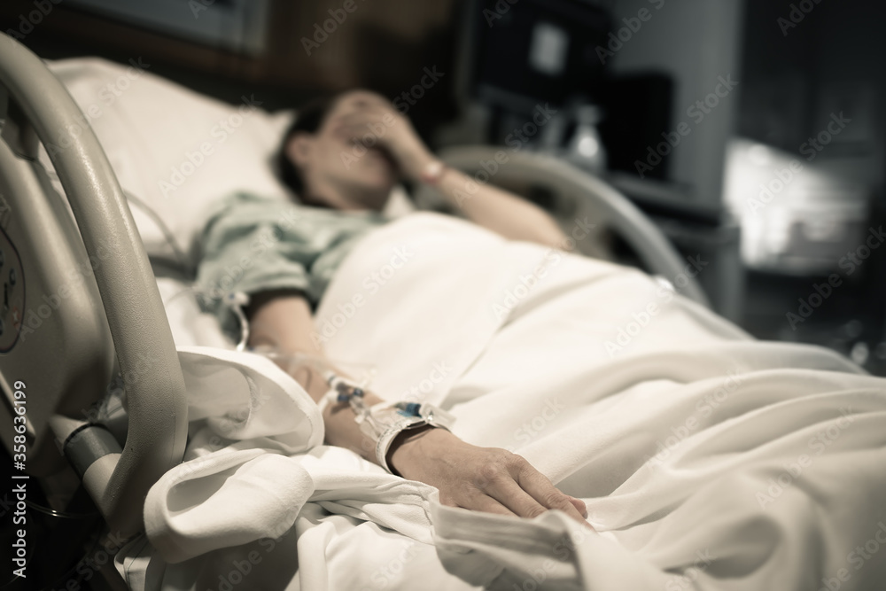 Sick woman lying in hospital bed. Stock Photo | Adobe Stock