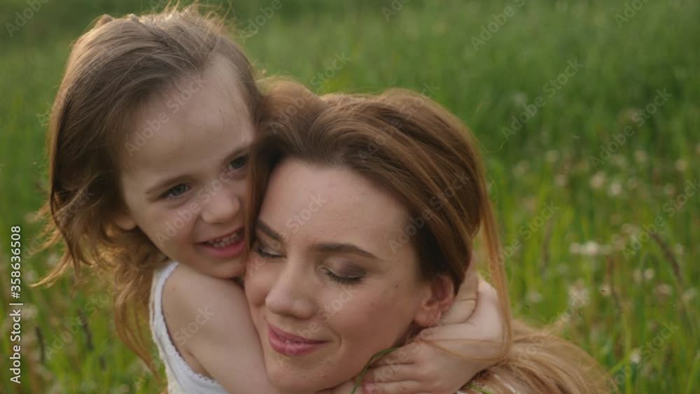 mom and daughter in the green field enjoy nature during sunset mom and daughter in the green field enjoy nature during sunset