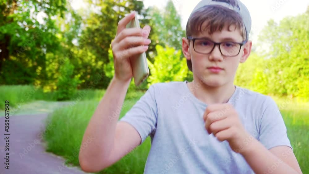 boy with smartphone in hands outdoors on a summer day. boy with smartphone in hands outdoors on a summer day.