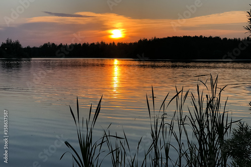 Beautiful sunset over the lake in summer warm evening