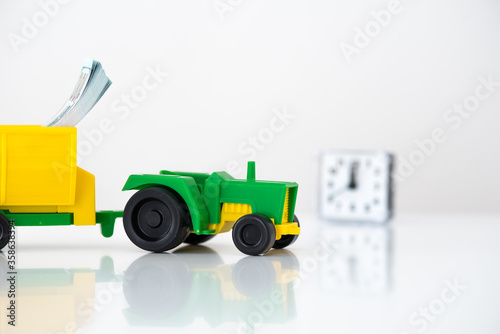 agricultural machinery on a white background. green tractor with a yellow trailer. time to invest in organic food. use as background or for advertising. © maxfotoadobe
