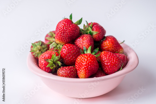 strawberries in a bowl on a white background