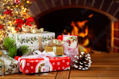 Boxes with gifts and Christmas decor on the background of the Christmas tree and fireplace. Close-up. Greeting card.