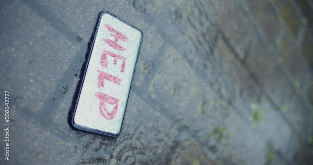 Undefined smartphone in the puddle. Word help on the screen. Kidnepping concept. Letting know that someone is in trouble. Message of victim. Crime scene. Peace of evidence. Vertical 4k video Undefined smartphone in the puddle. Word help on the screen. Kidnepping concept. Letting know that someone is in trouble. Message of victim. Crime scene. Peace of evidence. Vertical 4k video