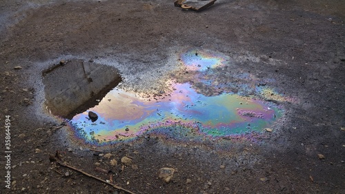 multicolored background, gasoline stains, rainbow streaks, abstract texture, wet asphalt picture, vertical fluid streams photo