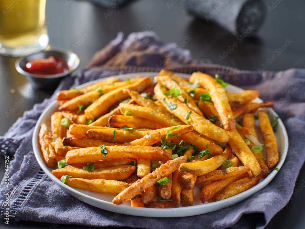 plate of crispy seasoned french fries with parsley garnish plate of crispy seasoned french fries with parsley garnish