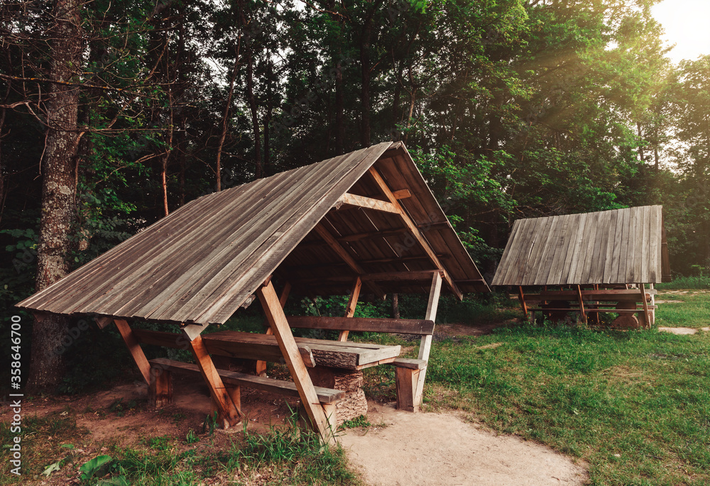 Wooden gazebo in forest for outdoor recreation. Wonderful nature place for leisure travelers Wooden gazebo in forest for outdoor recreation. Wonderful nature place for leisure travelers