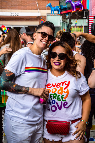 A lesbian couple is smiling and celebrating Gay Pride at a parade photo