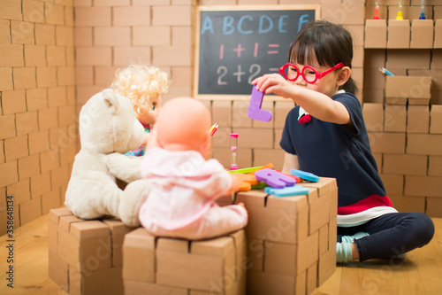 Photos toddler girl pretend play as a teacher at home